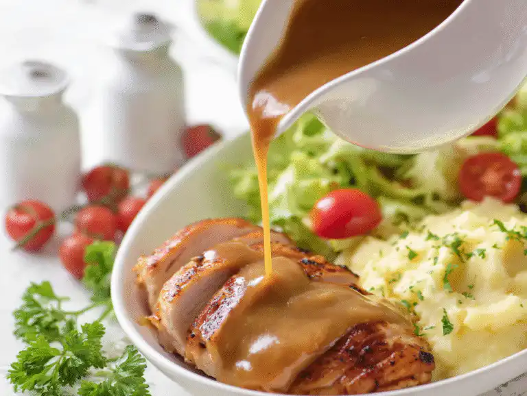 Crockpot Turkey Gravy: Easy Make-Ahead Recipe! 7 A white gravy boat filled with smooth, crockpot turkey gravy for Thanksgiving, on a bright white table.