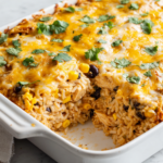 Southwest Cream Cheese Chicken Casserole in a white baking dish with melted cheese and fresh cilantro