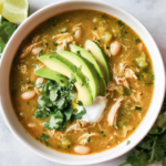 A bowl of easy salsa verde chicken soup topped with avocado and cilantro.